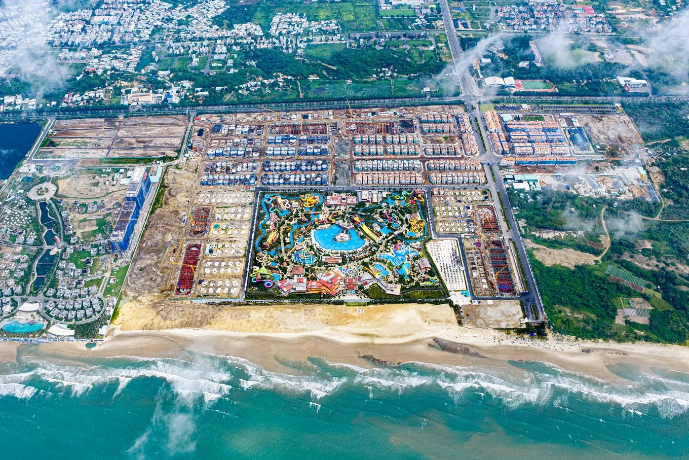 Toàn cảnh Blanca City từ trên cao tháng 9/2026 — công viên nước Sun World ở trung tâm, các dãy Casa và tháp căn hộ bao quanh, sát bờ biển Bãi Sau
